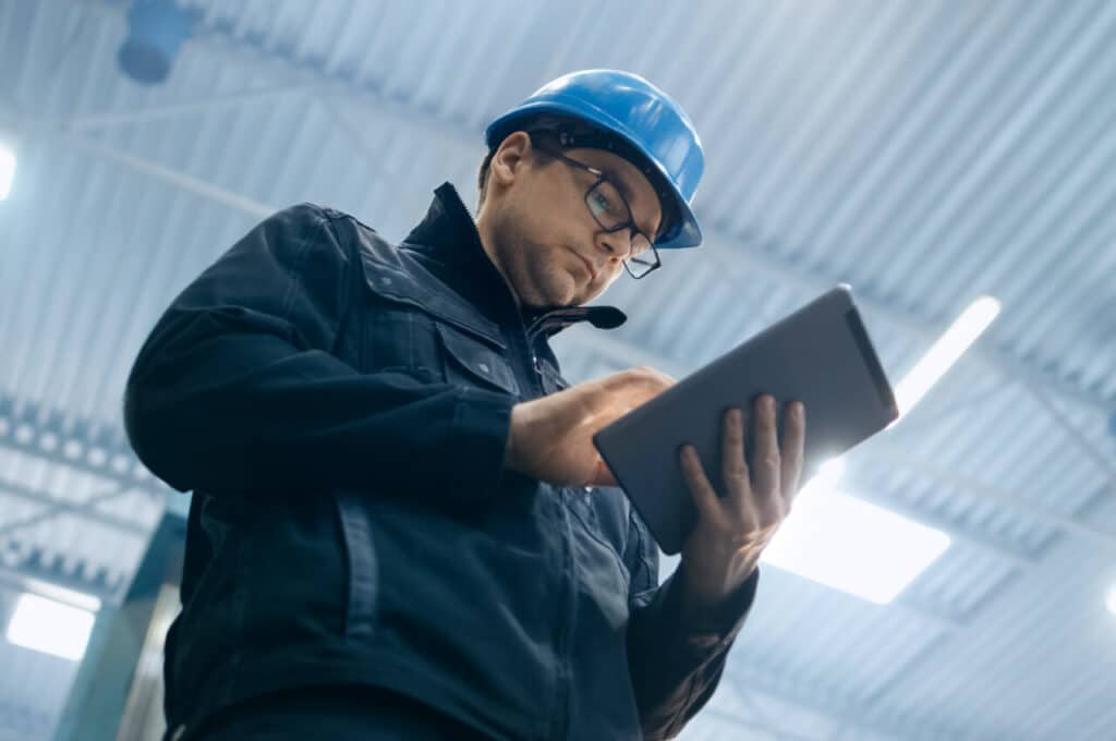 A man reviews manufacturing results on his iPad for his B2B company.