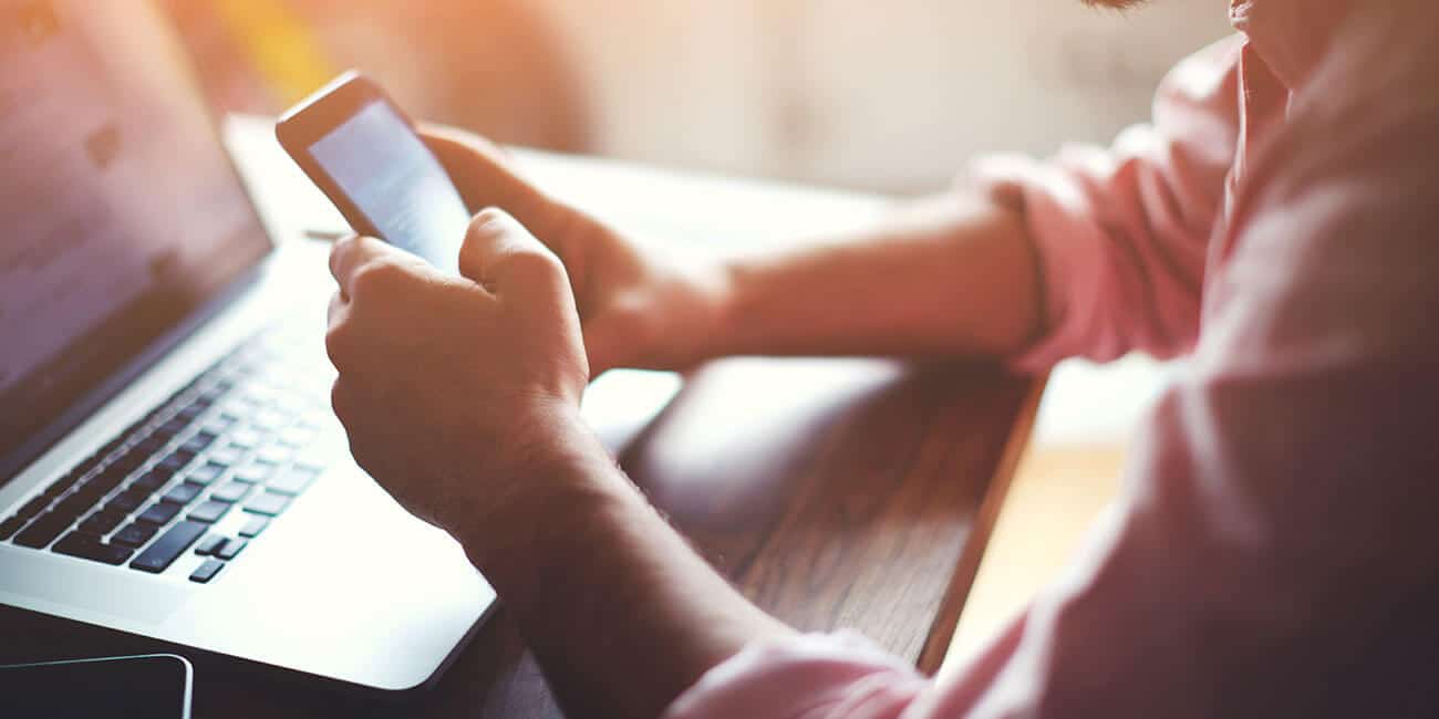 A person browsing their company's website on a mobile phone.