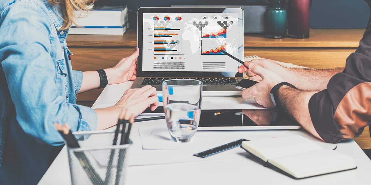 A management team reviews analytics on a computer, identifying trends for future promotions.